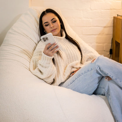 Woman scrolling on a pearl boucle lounger