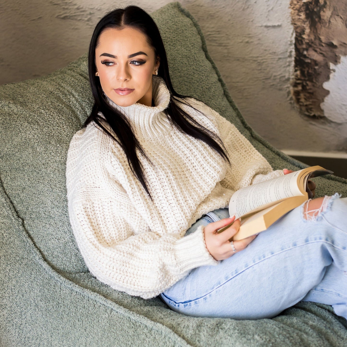 Woman reading on a boucle daybed chair